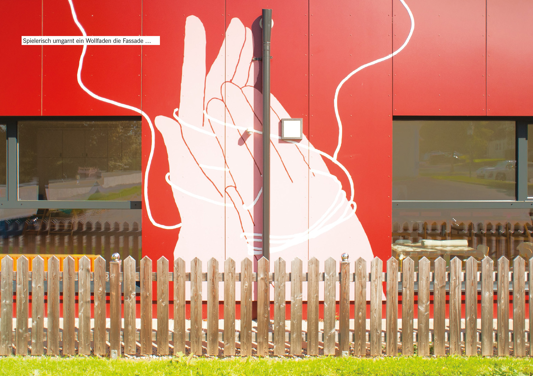 Spielerisch umgarnt ein Wollfaden die Fassade …